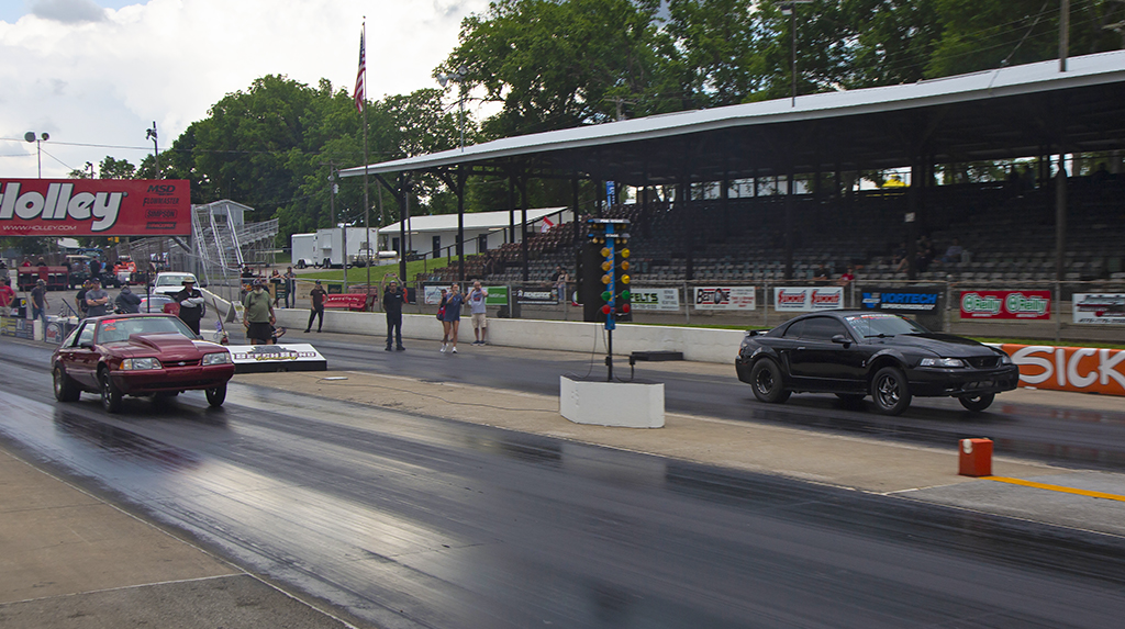 Two Ford mustangs drag race each other at Beech Bend Raceway in the TREMEC Stick Shift Shootout